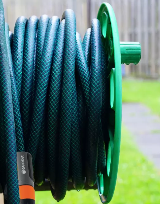 Nahaufnahme von zwei behandschuhten Händen, die an einem Winkelschleifer arbeiten.
